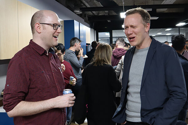Ritchie laughing while Kevin is standing next to him looking pleased